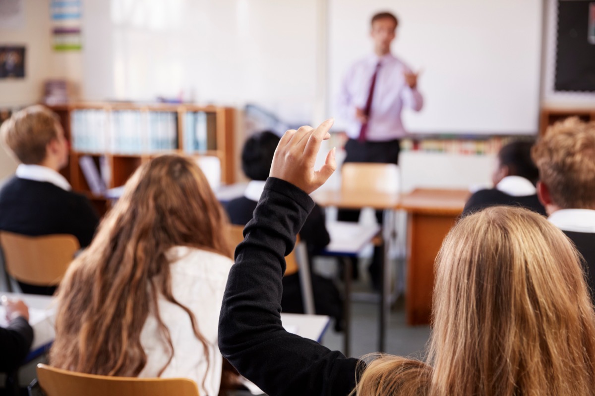 A student raising a hand to ask a question during a lesson.